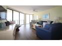 Spacious condo living room with ceiling fan, comfy seating and access to balcony with ocean views at 1690 N Waccamaw Dr. # 504, Garden City Beach, SC 29576