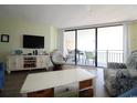 Inviting living room with entertainment center and comfortable seating, opens to a private balcony at 1690 N Waccamaw Dr. # 504, Garden City Beach, SC 29576