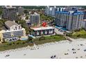 Aerial view of beachfront condo community with a pool, manicured lawn, steps to beach access and parking at 201 76Th Ave. N # D-3, Myrtle Beach, SC 29572
