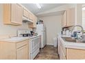 Galley kitchen with white appliances and light wood cabinetry at 2280 Andover Dr. # L, Surfside Beach, SC 29575