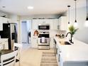 Modern kitchen with white cabinets, stainless steel appliances, subway tile backsplash and island seating at 230 Vermillion Dr., Little River, SC 29566