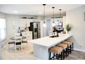 Bright, open kitchen features white cabinets, stainless steel appliances, and a large island with seating at 230 Vermillion Dr., Little River, SC 29566