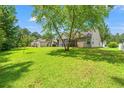 Expansive backyard with lush green grass and mature trees, ideal for outdoor activities at 2487 Windmill Way, Myrtle Beach, SC 29579