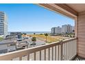 Enjoy amazing ocean views from this condo balcony overlooking the beach, palm trees, and local buildings at 2710 S Ocean Blvd. # 402, Myrtle Beach, SC 29577