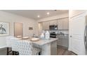 Kitchen featuring grey cabinets, stainless appliances, granite counters, and an island with seating at 2750 Riverboat Way, Conway, SC 29526