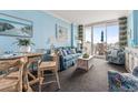 Charming living room with coastal decor, a cozy sofa, and a dining area with a view of the oceanfront balcony at 300 N Ocean Blvd. # 122, North Myrtle Beach, SC 29582