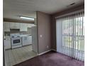 A kitchen area with white cabinets and appliances is seen from an adjacent carpeted living space at 300-J Myrtle Greens Dr. # J, Conway, SC 29526
