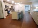 Bright kitchen featuring stainless steel appliances, tile backsplash, and an island with seating at 401 Quinta St., Longs, SC 29568
