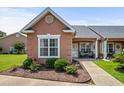 Charming condo exterior with lush landscaping, rose bushes, and a cozy front porch at 4648 Lightkeepers Way # 39A, Little River, SC 29566