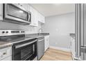 Modern kitchen features stainless steel appliances, granite counters, and white cabinets at 601 Mitchell Dr. # 207, Myrtle Beach, SC 29577