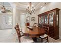 An elegant dining room with a chandelier, large wood table, display cabinet, and tiled floor at 7545 Ventura Ct., Myrtle Beach, SC 29572