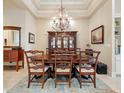 A dining room featuring a wooden table and chairs, cabinet, chandelier and floral rug at 7545 Ventura Ct., Myrtle Beach, SC 29572