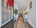 Bright entryway featuring hardwood floors, white walls adorned with art, and a decorative rug leading into the home at 816 Morrall Dr., North Myrtle Beach, SC 29582