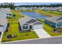 Aerial view of a well-maintained home backing onto a tranquil pond, surrounded by lush green lawns at 115 Spring Wheat Way, Conway, SC 29527