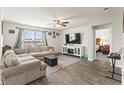 Inviting living room featuring hardwood floors, a comfortable sectional sofa, and a modern entertainment center at 115 Spring Wheat Way, Conway, SC 29527