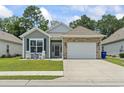Charming single-story home featuring a stone accented garage, rocking chairs, and a well-manicured lawn at 1178 Pyxie Moss Dr., Little River, SC 29566