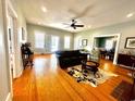 Spacious living room boasts gleaming hardwood floors, a ceiling fan, and a seamless flow into the dining area at 124 Orange St., Georgetown, SC 29440
