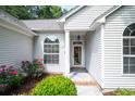 Inviting front entrance with elegant windows, stylish lighting, and a beautiful garden at 161 Patriot Ln., Pawleys Island, SC 29585