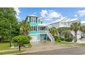 Charming two-story home with a vibrant turquoise exterior, white trim, and a well-manicured lawn at 17 Trigger Fish Ln., Murrells Inlet, SC 29576