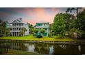 Scenic waterfront property featuring a charming two-story home with lush green lawn and mature trees at 17 Trigger Fish Ln., Murrells Inlet, SC 29576