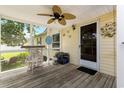 Relaxing screened porch features a ceiling fan and stylish decor, creating a cozy outdoor space at 259 Iroquis Trail, Longs, SC 29568