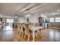 Open-concept dining room with seating for six, wood floors, connecting seamlessly to the living room and kitchen at 321 53Rd Ave. N, North Myrtle Beach, SC 29582