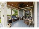 Inviting covered front porch with wood ceiling, comfortable seating, and decorative plants at 341 Bahama Dr., Murrells Inlet, SC 29576