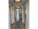 Inviting hallway with wood floors, neutral walls, detailed trim and attractive fish-themed rug at 371 S Dunes Dr., Pawleys Island, SC 29585