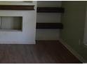 Minimalist living room featuring hardwood floors, fresh white walls and built-in dark wood shelving at 3909 Mallard Circle, Myrtle Beach, SC 29579