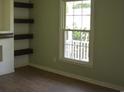 Bright living room with new light-colored walls, hardwood floors, a large window and wooden shelving at 3909 Mallard Circle, Myrtle Beach, SC 29579