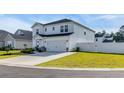 A bright, modern two-story home with a well-maintained lawn, a two car garage, and a charming fence at 4115 Bayhill St., Myrtle Beach, SC 29579