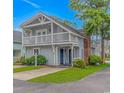 Charming two-story beach home with a balcony, covered entrance, and well-manicured landscaping at 4309 Beverly Ct., North Myrtle Beach, SC 29582