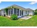 Backyard featuring a screened-in porch, lush greenery, and a small patio area at 435 Seneca St. Nw, Calabash, NC 28467
