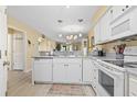 Modern kitchen with white appliances and cabinets and an open view to the dining area at 45 Pinehurst Ln. # 2C, Pawleys Island, SC 29585