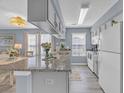 Bright kitchen with granite countertops, white cabinets, and modern stainless steel appliances at 5040 Windsor Green Way # 204, Myrtle Beach, SC 29579