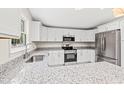 Modern kitchen featuring stainless steel appliances, granite countertops, and white cabinetry at 5074 Cowart Ct., Murrells Inlet, SC 29576