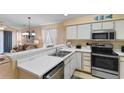 Bright kitchen with stainless steel appliances, breakfast bar, and open view to living area at 556 White River Dr. # 44F, Myrtle Beach, SC 29579