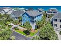 Stunning aerial view of blue beach home, showcasing its proximity to the ocean and lush surroundings at 573 S Dunes Dr., Pawleys Island, SC 29585