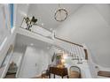 Bright foyer with soaring ceilings, showcasing staircase, modern chandelier, and stylish decor at 573 S Dunes Dr., Pawleys Island, SC 29585