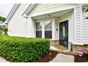 Charming entrance with a storm door, bay window, and neatly trimmed hedges under a covered area at 6095 Catalina Dr. # 714, North Myrtle Beach, SC 29582