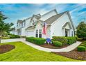 Inviting two-story home with manicured lawn, walkway, and flowerbeds under a beautiful blue sky at 6095 Catalina Dr. # 714, North Myrtle Beach, SC 29582