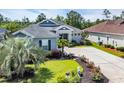 Inviting one-story home with landscaped front yard, beautiful plantings, and a wide driveway leading to the entrance at 773 Wintercreeper Dr., Longs, SC 29568