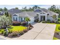 Attractive single-story home featuring a two-car garage, mature landscaping, and a concrete driveway at 773 Wintercreeper Dr., Longs, SC 29568