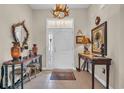 Elegant home foyer featuring a decorative antler chandelier, accent furniture, and tile flooring at 773 Wintercreeper Dr., Longs, SC 29568