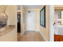 Hallway view to the unit entry and kitchen with tile flooring and neutral decor at 8121 Amalfi Pl. # 4-1006, Myrtle Beach, SC 29572