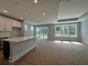 Spacious living room with large windows, recessed lighting, and adjacent kitchen area at 1005 Lady Bird Way, North Myrtle Beach, SC 29582