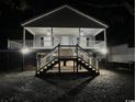 Night view of elevated beach house with inviting porch and stairs, showcasing outdoor lighting at 1022 Waccamaw Dr., Conway, SC 29526