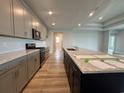 Modern kitchen with a large center island, granite countertops, and stainless steel appliances at 1117 Oxeye St., North Myrtle Beach, SC 29582