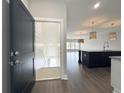 Open concept entryway with dark door, leading to kitchen and staircase with durable hardwood flooring throughout at 135A Sunset Dr., Murrells Inlet, SC 29576