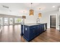 Stylish kitchen island, hardwood flooring, modern sink and stainless steel appliances, and modern lighting at 135A Sunset Dr., Murrells Inlet, SC 29576